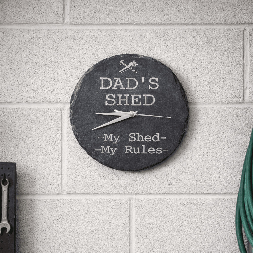 Handcrafted 22cm Dad’s Shed slate clock with “My Shed My Rules” design mounted on a white brick garage wall Handcrafted 22cm Dad’s Shed slate clock with “My Shed My Rules” design mounted on a white brick garage wall