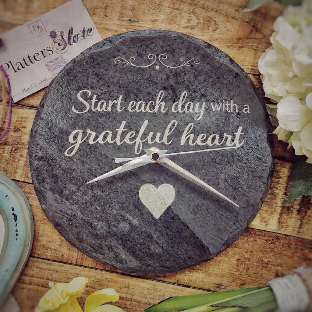 Handcrafted slate wall clock engraved with “Start each day with a grateful heart,” displayed in a country kitchen, ideal as a Mother’s Day gift or thoughtful gift for her Handcrafted slate wall clock engraved with “Start each day with a grateful heart,” displayed in a country kitchen, ideal as a Mother’s Day gift or thoughtful gift for her